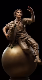 a statue of a man and a dog sitting on top of a ball