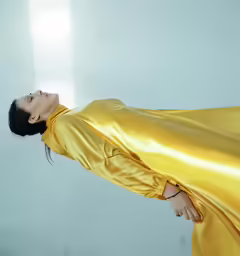 the woman is posing in an all yellow dress