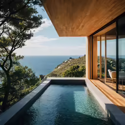 a pool outside of a large house next to the ocean