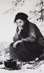 a woman sitting down while smoking on a cigarette