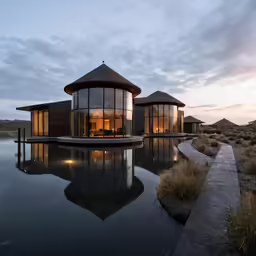a luxurious house sitting on the edge of a lake