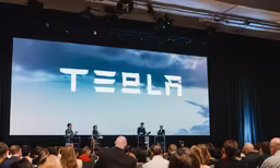 four people are at a meeting in front of a projected tezlip image