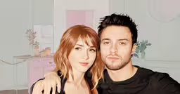 the man and woman pose for the camera,a young man and woman are posing for the camera