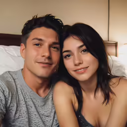 a man and woman sitting together in bed