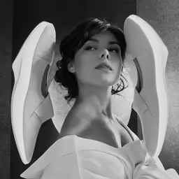 a woman in a white dress is wearing a pair of wings