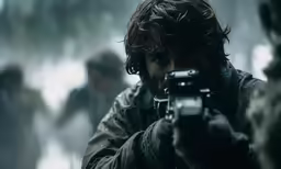 a man holding a gun while wearing a jacket
