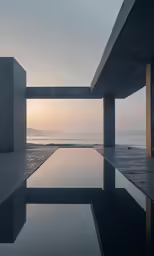 a modern concrete pool with an ocean view