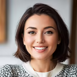 smiling woman with short hair wearing a black and white jacket