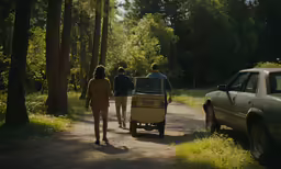 people walking in the woods holding onto their luggage