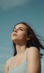 a woman is wearing a tank top and has long hair