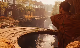 man looking at waterway with bridge in distance on sunny day