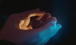 the person is holding a small piece of food