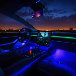 a car dashboard with lights showing and a phone in the dash