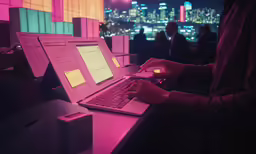 a person working on a laptop with neon lights