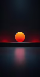 the sun is setting over an orange ball