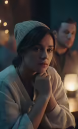 a woman sits in front of two people