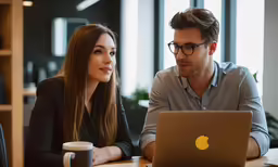 a man and woman are looking at a computer