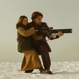 a man and woman are holding a gun