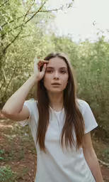 a woman with long hair standing in the woods