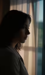 a young woman looking out the window looking into the distance