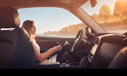 a woman is in the drivers seat of a vehicle