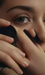 a woman with brown eyes looking through her lens