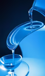 water is flowing into a glass on a table