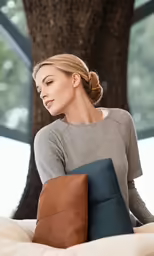 a woman sitting on a bed looking off to her side