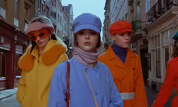three women with sun glasses wearing brightly colored outfits