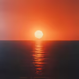 the sun is setting over the ocean with calm waves