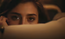 a close up of a person laying down with her hand on her chin