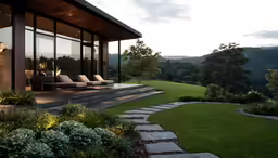 some chairs sitting outside of a glass building on a hill