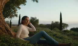 a young woman sitting on the ground with her eyes closed