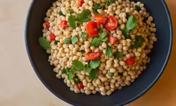 a bowl full of food including corn and tomatoes