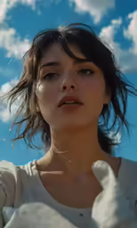 young woman standing in the sun with her hands folded