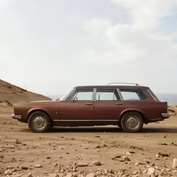 an old car is parked on the side of a hill