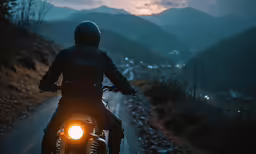 a man riding on the back of a motorcycle down a country road