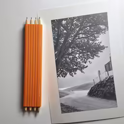 a pencil lying next to an empty photograph