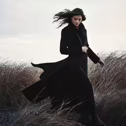 a woman is walking through the grass