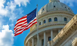 two flags in front of a white, domed building
