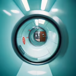 an eye - looking view of a blue wall with a doorway and small red exit sign