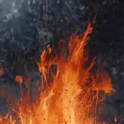 the fire is blazing as it erupts orange, flamed ash