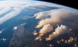 aerial view of clouds and land with blue sky