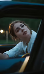 a woman in a car, sitting behind the wheel