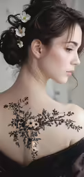 a woman with flowers on her back shoulder tattoo