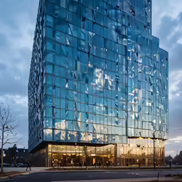 this is an image of a large glass building at sunset