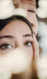 two people looking in opposite directions while one woman holds her eye closed