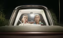 two people sitting inside of a pick up truck
