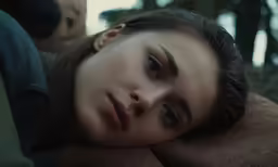 the young woman is laying on a cushion