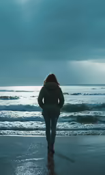 the woman is walking alone on the beach